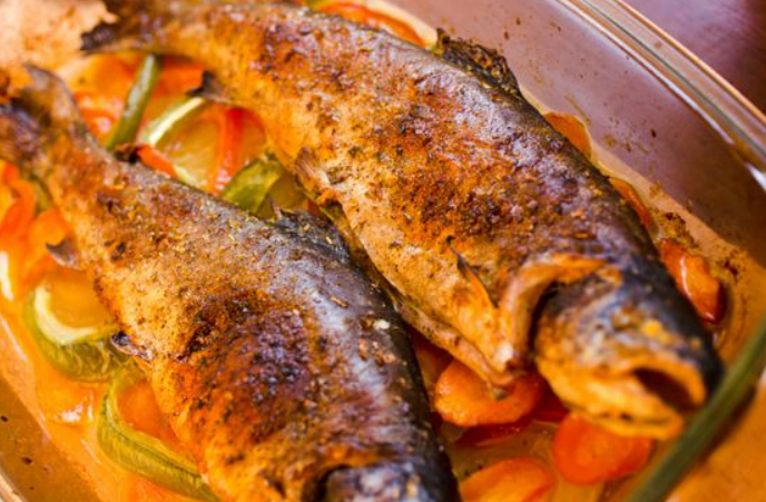 2 trout fish cooked in a vegetable gravy
