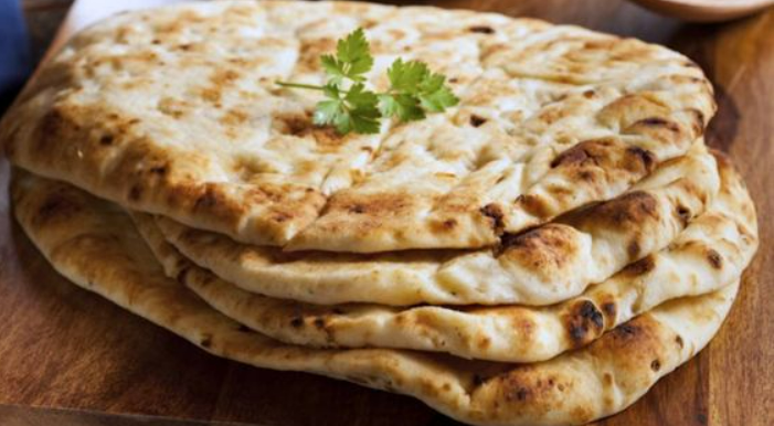 Large, round, fluffy flatbreads garnished with coriander leaves