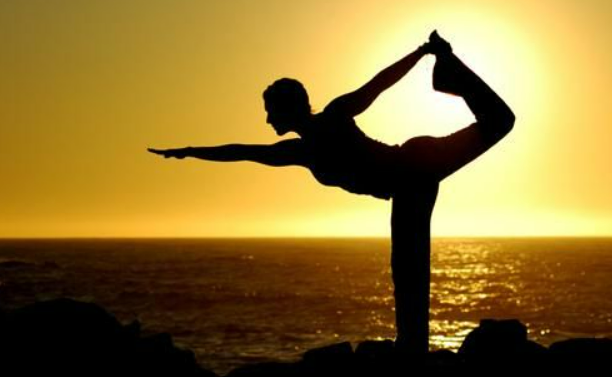 Women practicing yoga pose by the Varkala Beach in Kerala